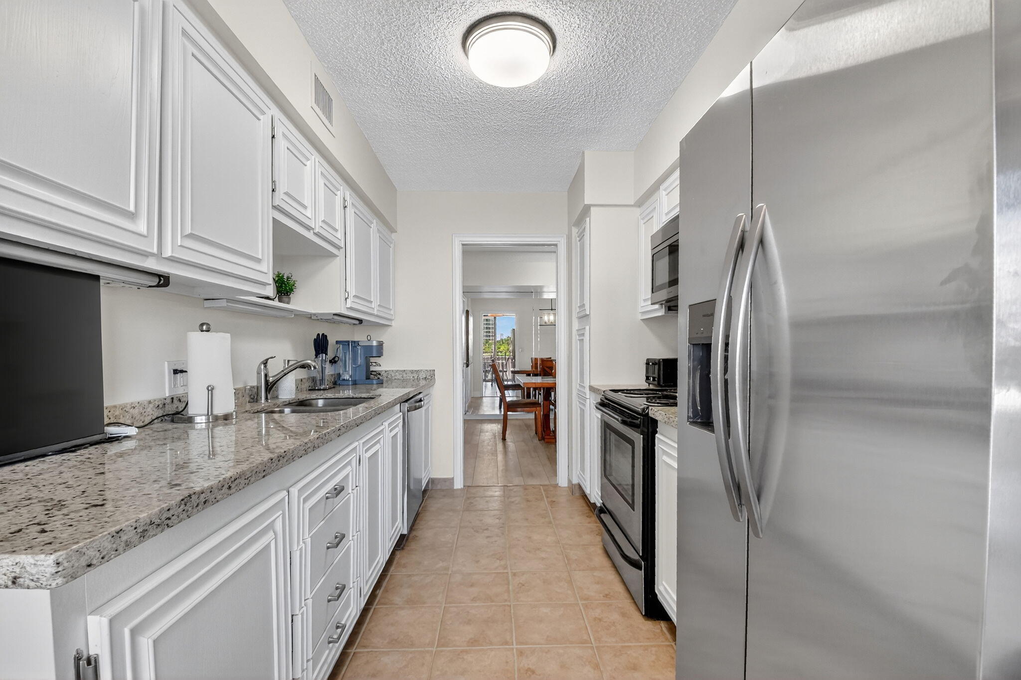 3400 North Ocean Drive, Unit 405 Riviera Beach, FL 33404 - Photo 13 of 58 a kitchen with granite countertop a refrigerator oven a sink and dishwasher