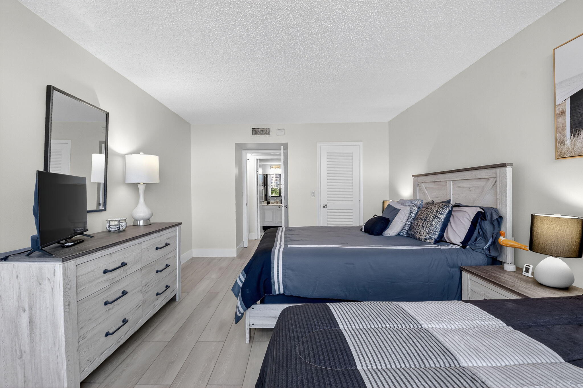 3400 North Ocean Drive, Unit 405 Riviera Beach, FL 33404 - Photo 24 of 58 a room with a bed and flat tv screen on the dresser