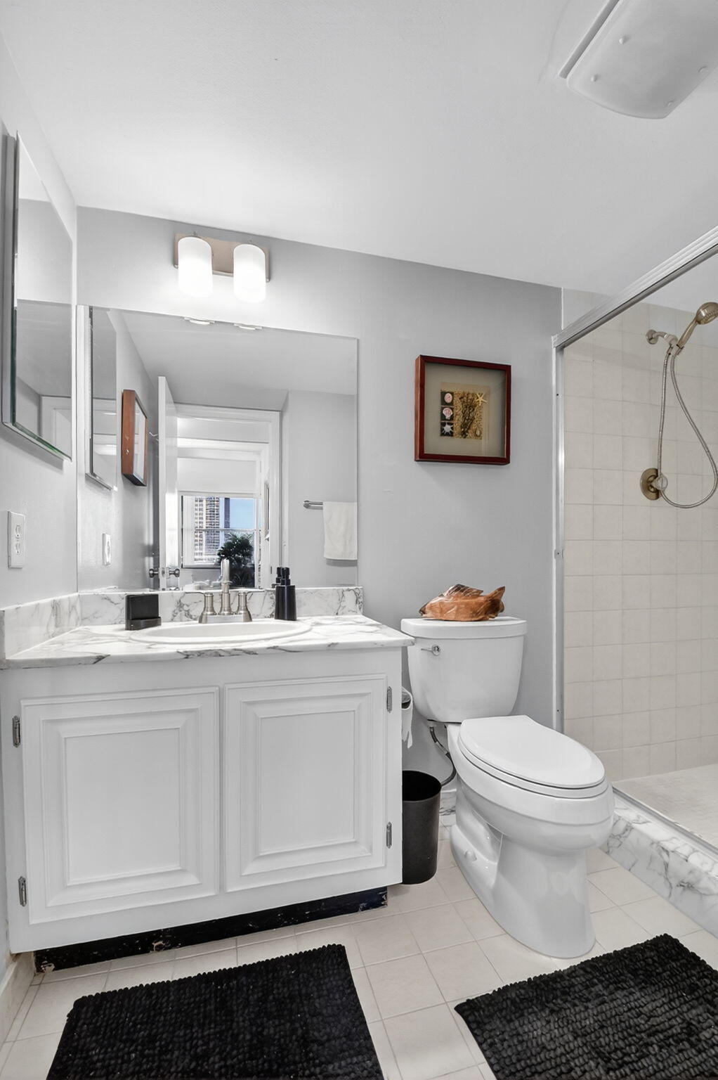 3400 North Ocean Drive, Unit 405 Riviera Beach, FL 33404 - Photo 26 of 58 a bathroom with a sink a toilet and a mirror