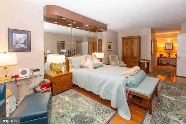 a bedroom with a bed and dresser with mirror