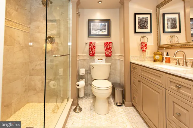 a bathroom with a toilet sink and a large mirror