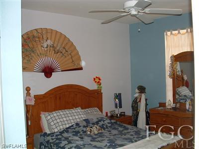 8632 Stringfellow Road St. James City, FL 33956 - Photo 5 of 10 a bedroom with a bed and a chandelier