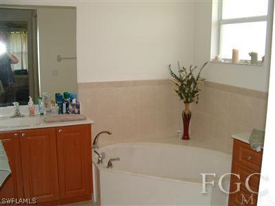8632 Stringfellow Road St. James City, FL 33956 - Photo 7 of 10 a bathroom with a tub sink and mirror