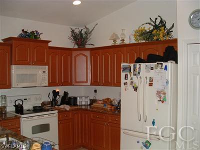 8632 Stringfellow Road St. James City, FL 33956 - Photo 9 of 10 a kitchen with stainless steel appliances a stove a refrigerator a sink and cabinets