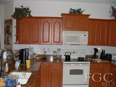 8632 Stringfellow Road St. James City, FL 33956 - Photo 10 of 10 a kitchen with stainless steel appliances granite countertop a refrigerator a stove top oven a sink and dishwasher