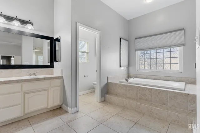 a spacious bathroom with a mirror a bathtub and a shower
