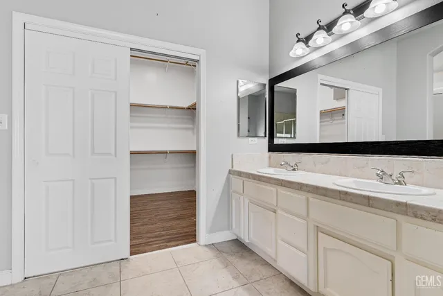 a bathroom with a double vanity sink a mirror and a bathtub