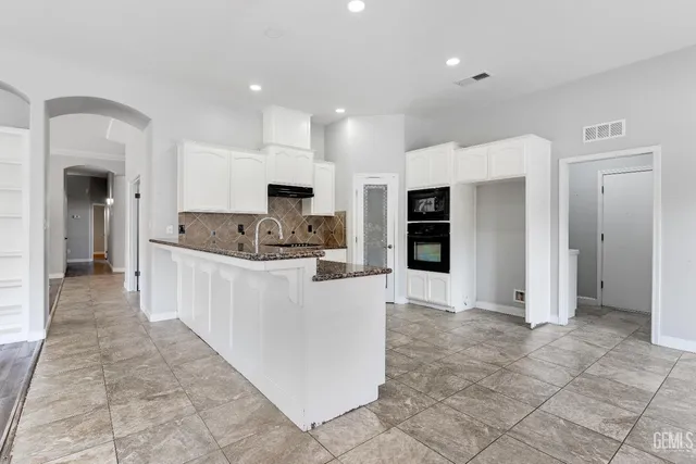 a large kitchen with cabinets and stainless steel appliances