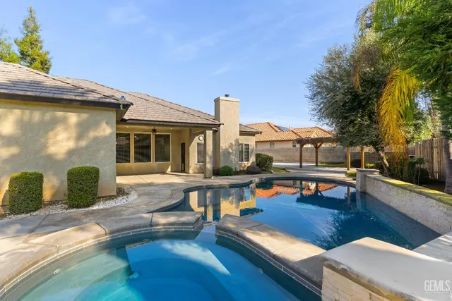 a view of a park with large trees and a wooden fence