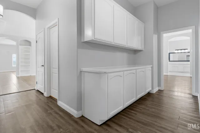 a view of a kitchen with wooden floor and cabinets