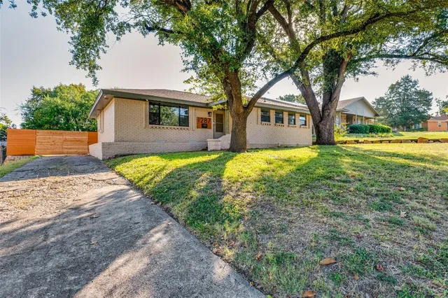 a front view of a house with yard and green space