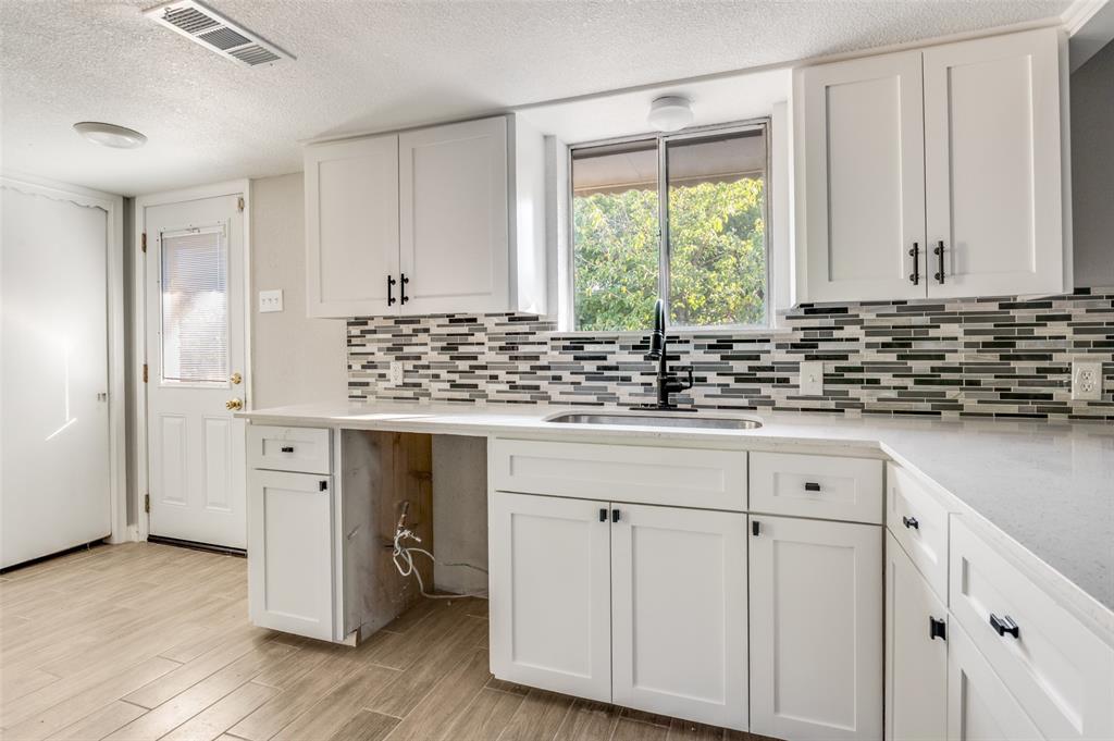 1287 Whispering Trail Dallas, TX 75241 - Photo 13 of 24 a kitchen with white cabinets and window