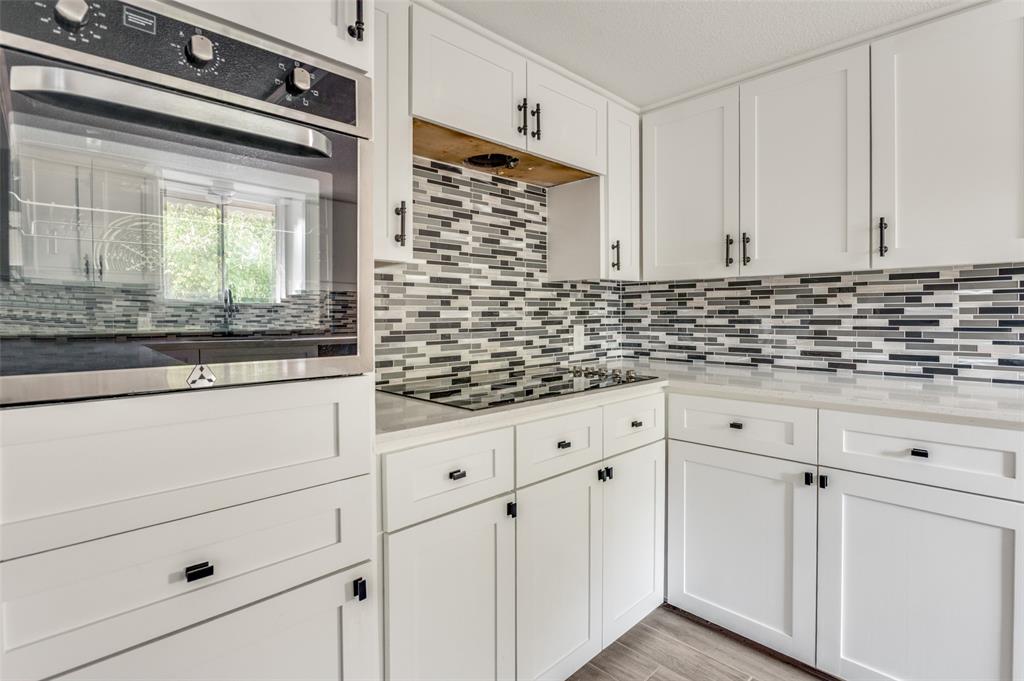 1287 Whispering Trail Dallas, TX 75241 - Photo 14 of 24 a kitchen with granite countertop white cabinets and white appliances