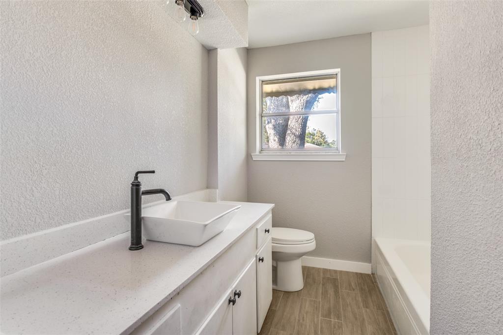 1287 Whispering Trail Dallas, TX 75241 - Photo 18 of 24 a bathroom with a sink a toilet and a window