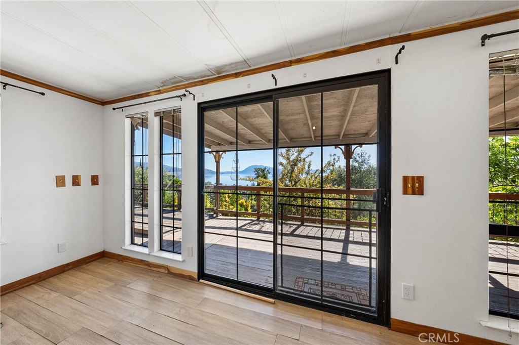 3360 Yuba Street Nice, CA 95464 - Photo 15 of 50 en empty room with sliding glass door and wooden floor