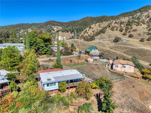 an aerial view of house with yard and mountain view in back