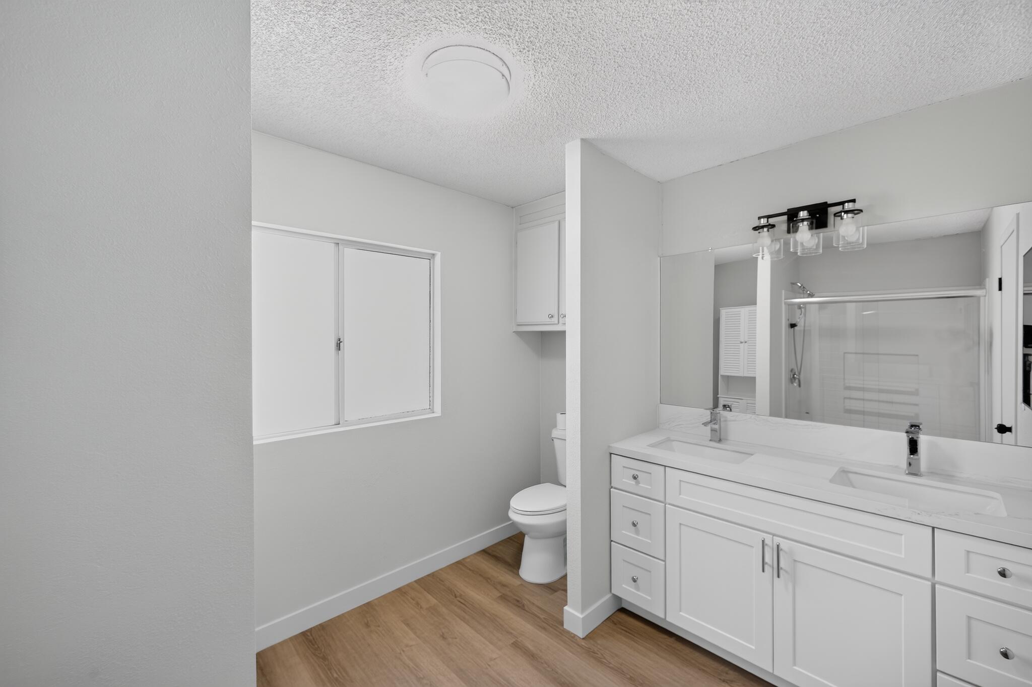 15181 Van Buren Boulevard, Unit 102 Riverside, CA 92504 - Photo 24 of 29 a spacious bathroom with 2 sink toilet and a mirror