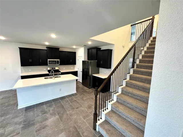 a view of living room kitchen with stainless steel appliances and couch