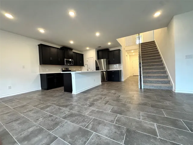 a view of kitchen with kitchen island microwave and refrigerator