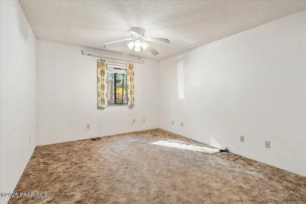 an empty room with windows and cabinet