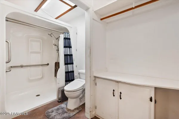 a spacious bathroom with a double vanity sink a large mirror and shower