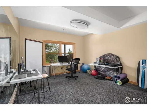 a living room with furniture a large window and gym equipment