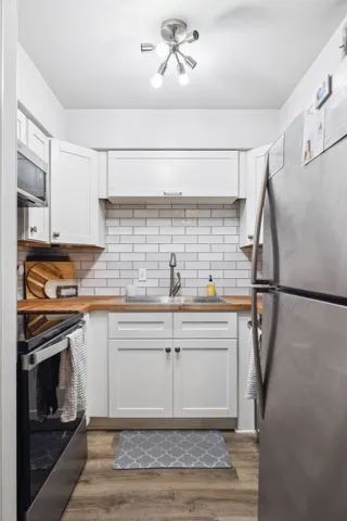 a kitchen with stainless steel appliances granite countertop a sink stove and refrigerator