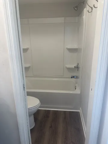a white bath tub sitting next to a toilet