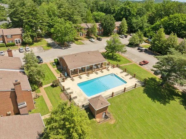 an aerial view of residential houses with outdoor space and trees