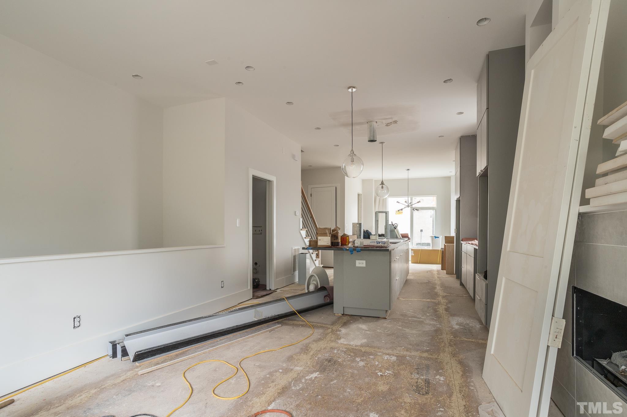 719 Willard Street Durham, NC 27701 - Photo 4 of 24 a view of a kitchen with fridge and wooden floor