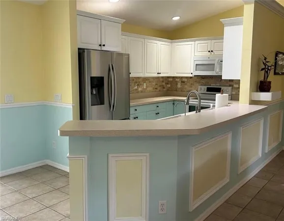 a kitchen with stainless steel appliances a refrigerator and a stove top oven