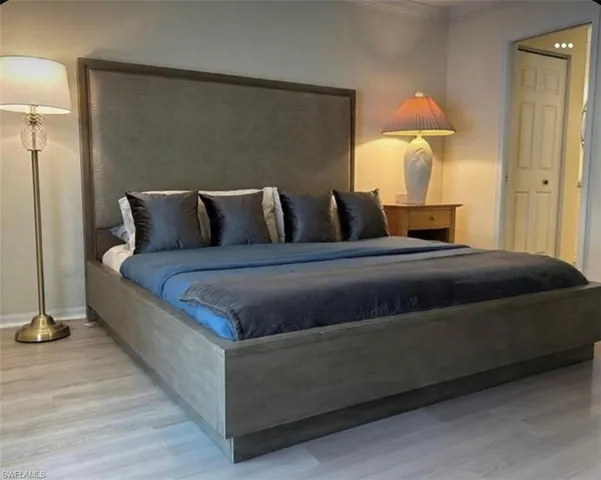 a large bed sitting in a bedroom next to a lamp