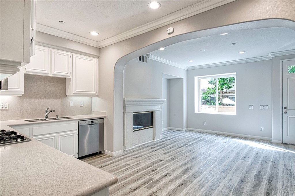 83 Sapphire, Unit 46 Irvine, CA 92602 - Photo 7 of 18 a view of a kitchen with a sink dishwasher and a fireplace