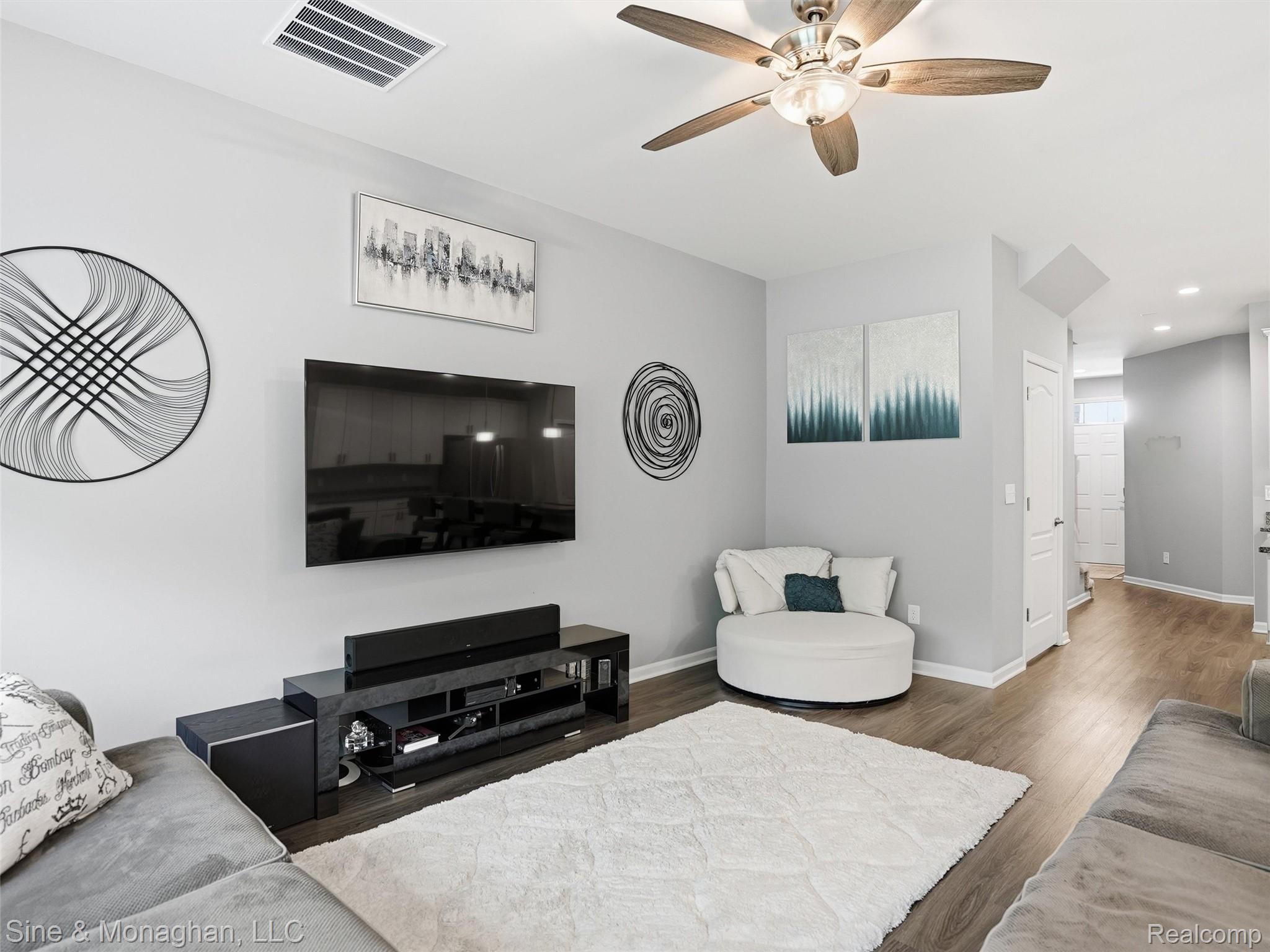 24827 Ivy Road Novi, MI 48375 - Photo 13 of 38 Open-concept living space featuring wood-finish flooring, light gray walls, a ceiling fan with integrated lighting, and white baseboards