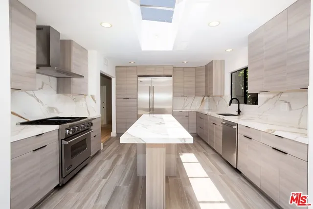 a large kitchen with a stove sink and cabinets