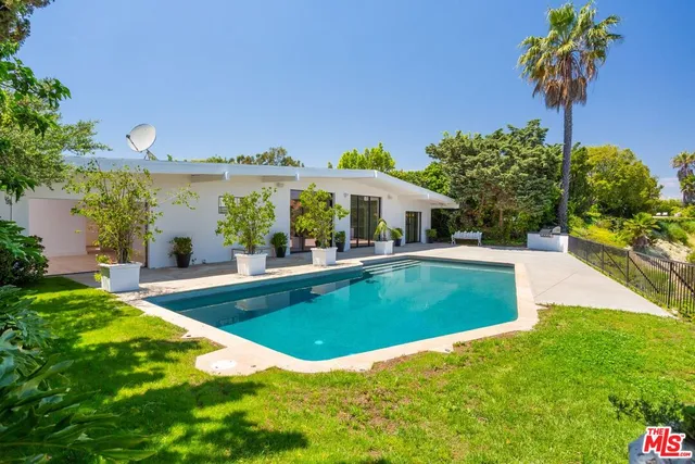 a view of a big room with wooden floor and windows