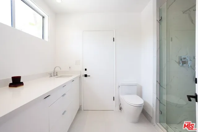 an empty room with wooden floor closet and windows
