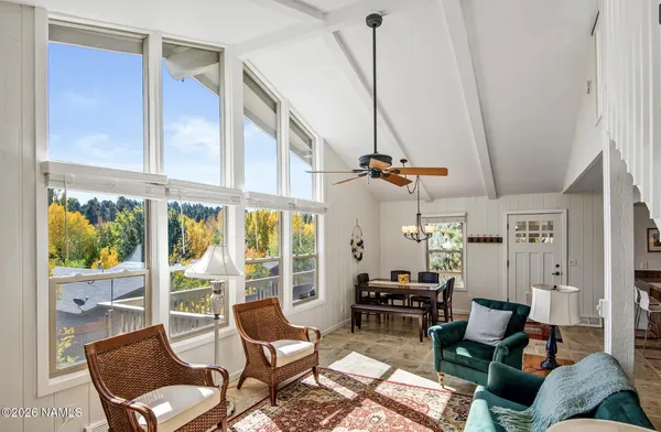 a living room with furniture and floor to ceiling windows