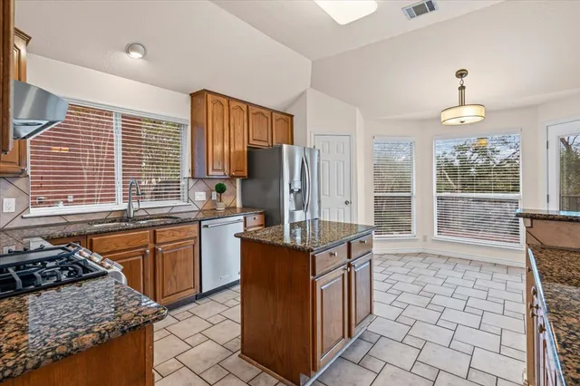 a kitchen with granite countertop a sink and a stove