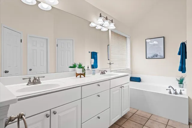 a view of an empty room with wooden floor and a ceiling fan