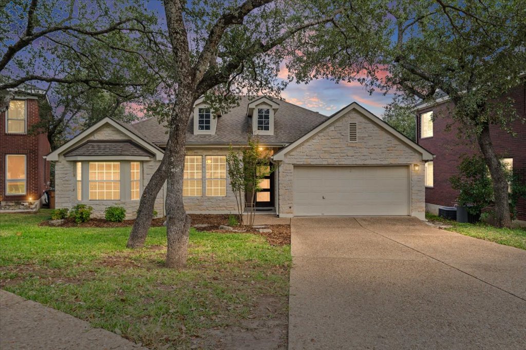 8111 Davis Mountain Pass Austin, TX 78726 - Photo 2 of 37 a front view of a house with a yard and garage