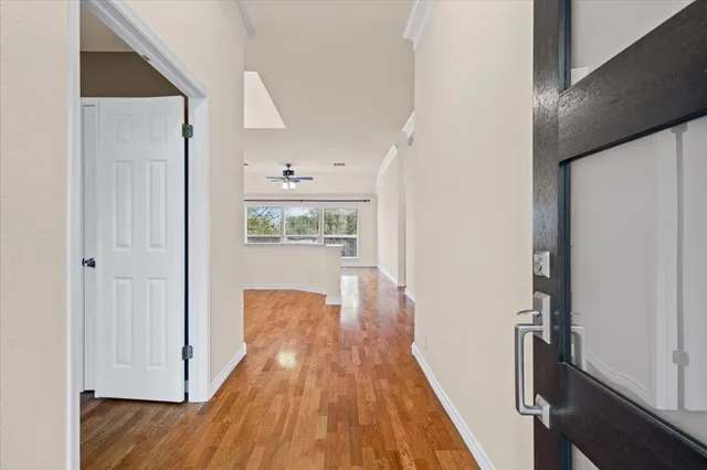 a view of a hallway with wooden floor and staircase