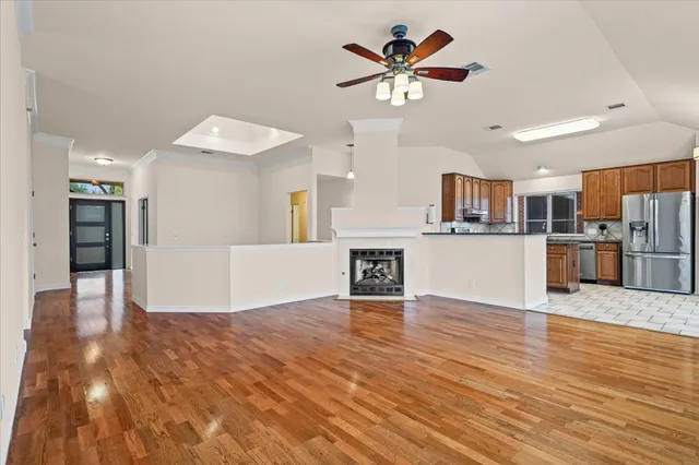 a view of a kitchen with a kitchen island wooden floor and a ceiling fan