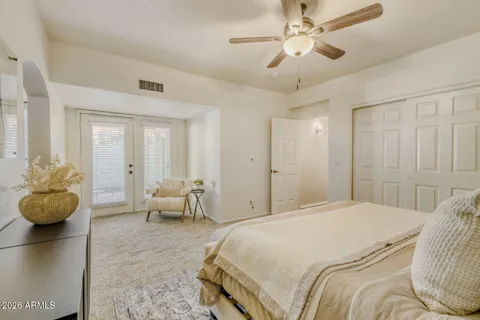 a spacious bedroom with a bed and ceiling fan