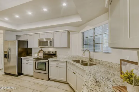 a kitchen with granite countertop a sink stainless steel appliances and cabinets