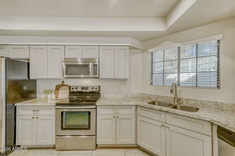 a kitchen with appliances a sink and cabinets