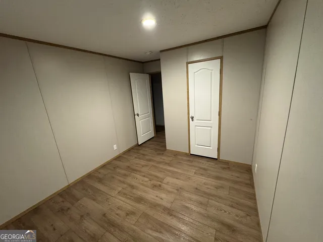 an empty room with wooden floor and window