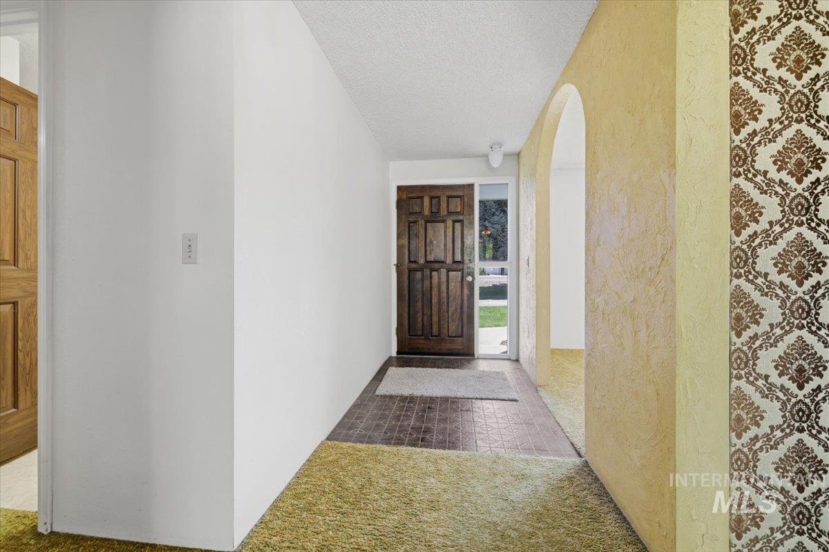 1311 North Middleton Road Nampa, ID 83651 - Photo 16 of 49 Entryway featuring a paneled wood door with sidelight, tile flooring, and an arched hallway opening