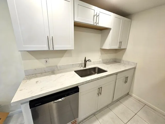 a kitchen with a sink dishwasher and cabinets