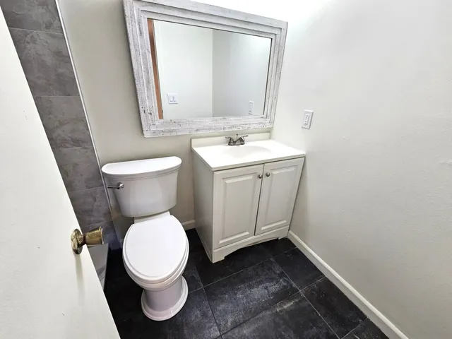 a bathroom with a toilet sink and mirror